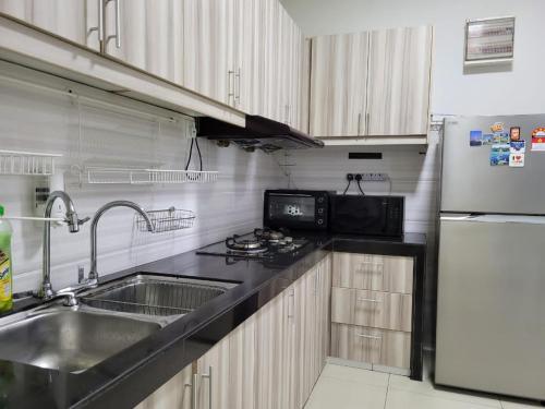 史里肯邦安HOMESTAY D'Univ 360 PLACE的厨房配有水槽和冰箱