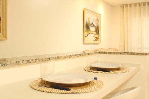卡斯卡韦尔APTO completo para sua família!的上面有两个盘子和碗的白色柜台