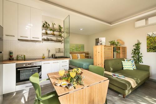 瓦莫斯Olive Lemon Biophilic House & Lush Forest Garden的厨房以及带桌子和沙发的客厅。