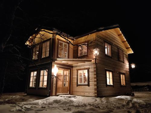 KoskullskulleAurora Nova的木屋,晚上有灯光在雪中