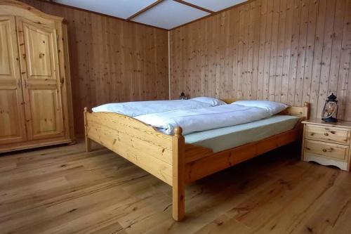 贝阿滕贝格Känzeli - Ferienwohnung mit Traumaussicht的木质地板客房中的一张木床