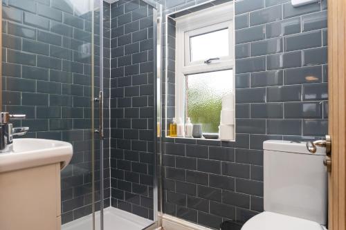 布里斯托Relaxation by Olauda SA - 3 Bed House with Free Parking的浴室设有卫生间和蓝色瓷砖淋浴。