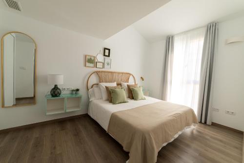 格拉纳达Apartamentos con encanto en el centro de Granada的白色卧室设有一张大床和镜子