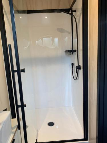 奥阿库尼Snowman Cabins的浴室内带玻璃门的白色淋浴