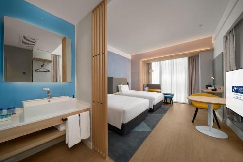 南昌南昌方大智选假日酒店的酒店客房设有床、水槽和浴缸。