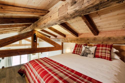 莫尔济讷Petit Lumina的木制天花板的客房内的一张床位
