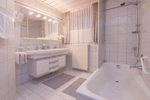 萨尔巴赫米莱特公寓的浴室配有水槽、淋浴和浴缸。