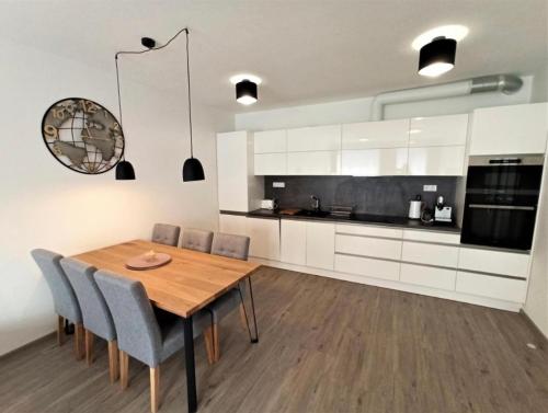 伏尔塔瓦河畔利普诺Lipno Port Apartment A103的厨房配有木制用餐室的桌椅