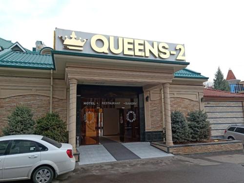 塔什干Queens 2 hotel的停在商店前的白色汽车