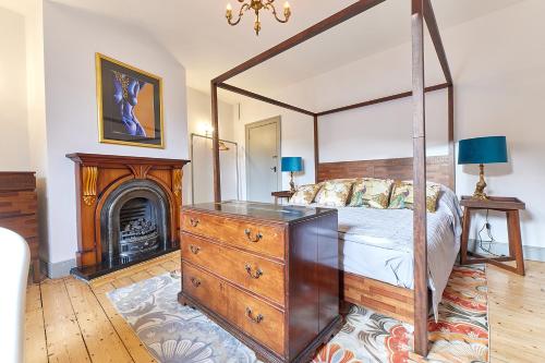 泰恩茅斯Host & Stay - Peacock House的一间卧室设有一张天蓬床和一个壁炉