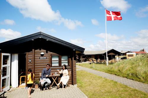 乌尔夫堡Fjand Badeby - Guesthouse, Cottages and Colony的一群人站在船舱外,悬挂着旗帜