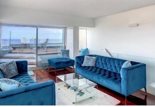 卡尼索Luxurious Penthouse Suite direct at sea的客厅配有2张蓝色的沙发和1张桌子