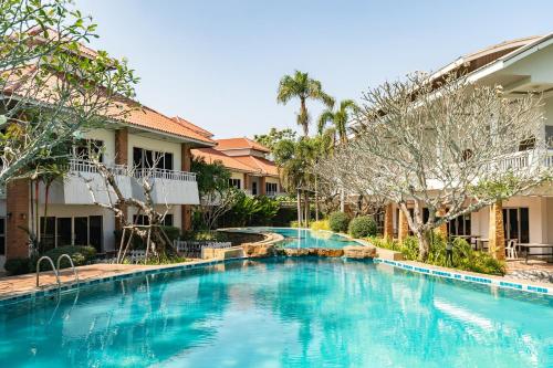 坤西育府Thara Cholapruek Resort - SHA Extra Plus的一座树木繁茂的房屋前的游泳池