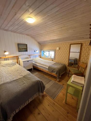 耶尔夫瑟Chinova Mötesgård i Järvsö的一间卧室配有两张床和一张书桌。
