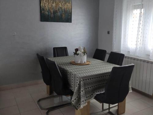 萨格勒布Apartment Roki的餐桌,带黑色椅子和蛋糕
