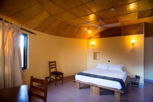 瓦加杜古格兰德卡劳宾馆的一间卧室设有一张床和木制天花板
