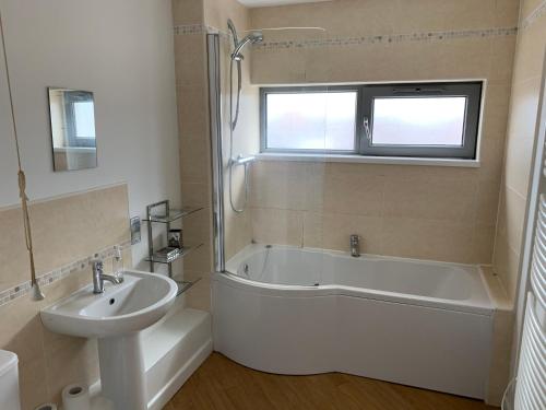 达灵顿Central Darlington Apartment With Parking的浴室配有盥洗盆、浴缸和盥洗盆