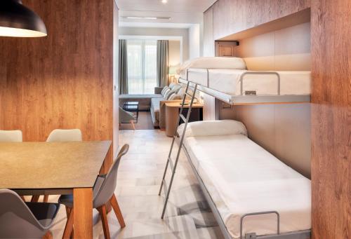 塞维利亚圣巴勃罗塞维利亚酒店的客房设有三张双层床和一张桌子。