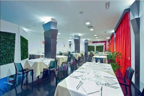圣萨尔沃埃登酒店的用餐室配有白色的桌子和蓝色的椅子