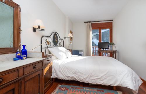 埃尔塔特Apartament Terrasses F的一间卧室配有一张床、一个梳妆台和一扇窗户。