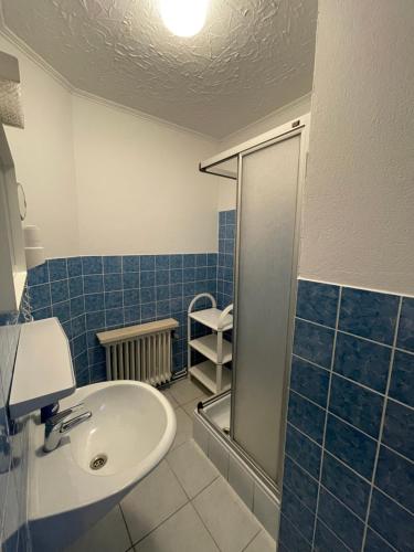 弗里索伊特Ferien- & Monteurzimmer Markhausen的蓝色瓷砖浴室设有水槽和淋浴
