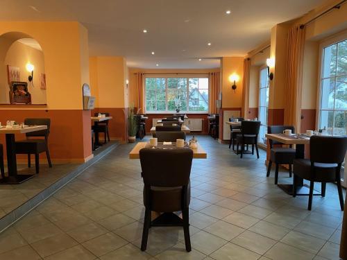 格拉尔-米里茨Hotel Villa Strandkorb的餐厅设有桌椅和窗户。