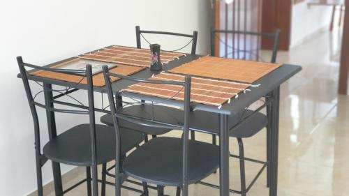 格兰贝伊CHEZ JOHNNY的一张桌子、四把椅子和一张黑桌子