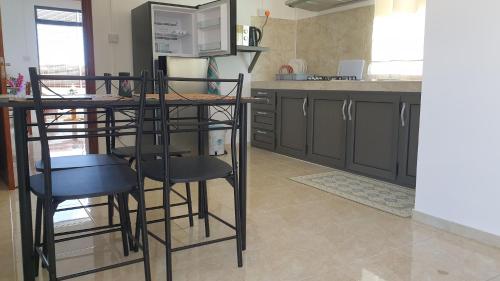 格兰贝伊CHEZ JOHNNY的厨房配有桌椅和微波炉。
