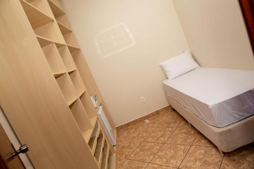 阿瓜斯迪林多亚Pousada Costa Rielli的小房间设有床和书架