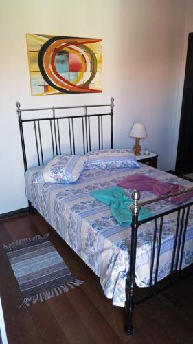 阿雷格里港Espaço Trilegal的卧室配有一张床,墙上挂有绘画作品