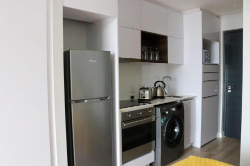 开普敦2218 at 16 on Bree的厨房配有冰箱和洗衣机。