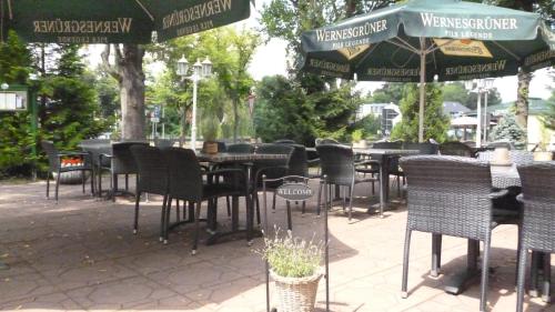 沃尔特斯多夫科拉尼克斯博格餐厅酒店的一组桌椅和遮阳伞