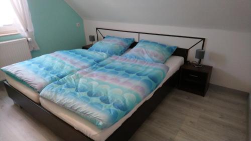 VöhlFerienhaus Scheerer的一张带蓝色棉被和枕头的大床