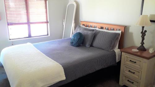 汉密尔顿Quiet location ,central to city的一间卧室配有一张带蓝色枕头的床