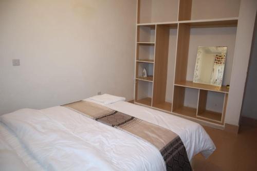 NarokLux Suites Mara Holiday Homes的卧室配有白色的床和镜子