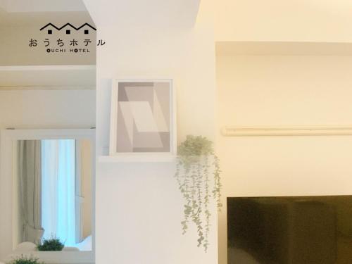 广岛OUCHI HOTEL Fujimi的一间设有白色墙壁、镜子和植物的房间
