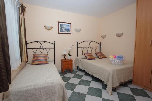 马贝拉阿杜阿尔旅馆的卧室内两张并排的床