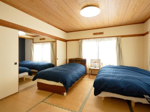 千岁LY INN CHITOSEAIPORT - Vacation STAY 94792的一间卧室,配有三张床
