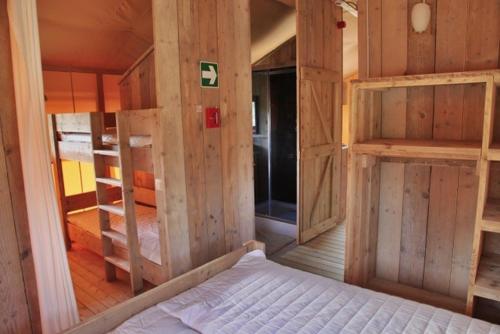龙塞Ijsmolenhoeve的一间带木墙的卧室和一张位于客房内的床