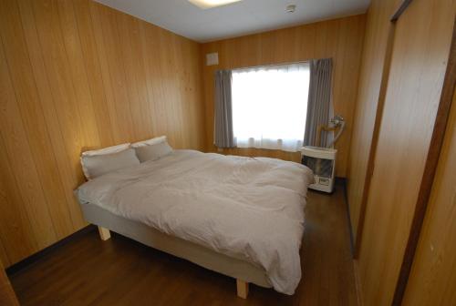 远轻町Tarochan House的一间卧室设有一张大床和窗户