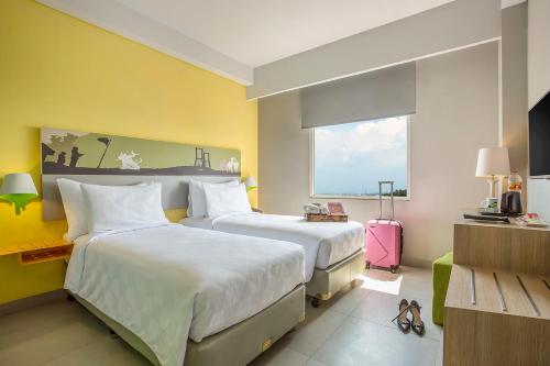 泗水KHAS Surabaya的酒店客房设有两张床和窗户。