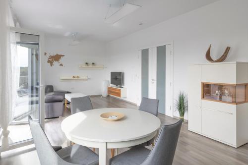 不来梅港Moderne 2 Zimmer Ferienwohnung mit Dachterrasse - 95qm的白色的用餐室配有白色的桌椅