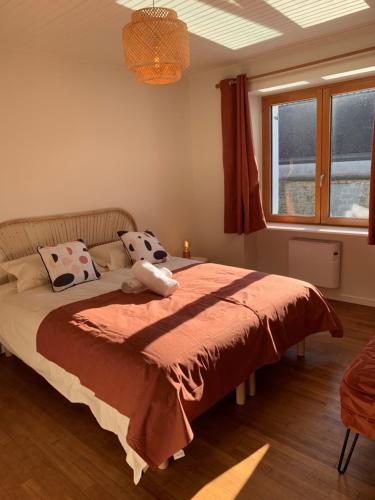 吉代勒Maison à 800 m à pied de la plage的一间卧室配有一张带红色毯子的床和窗户。