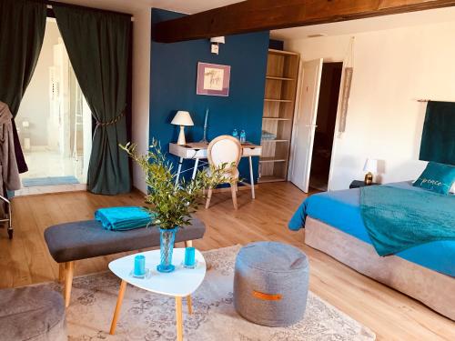 蒙托邦Manoir de la Gravette Maison d'Hôtes的蓝色卧室,配有床和桌子