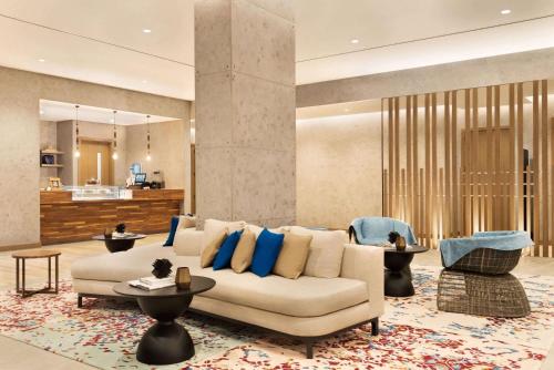 迪拜Days Hotel By Wyndham Dubai Deira的客厅配有白色沙发和蓝色枕头。