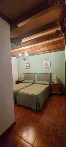 Cazalegas 马奎斯度假屋的一间带一张床的卧室,位于带木制天花板的房间内