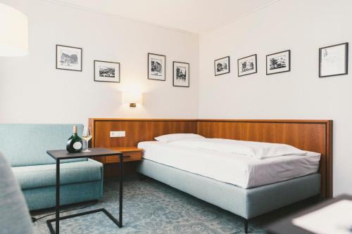索梅劳森Weingut Pastoriushaus - Artur Steinmann的卧室配有一张床和一张桌子,墙上挂有图片