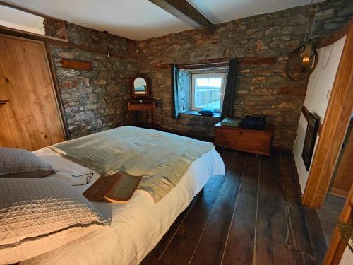 斯图蒙Le Clos des Brumes的一间卧室设有一张床和石墙