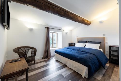 MusLa Maison d'à Côté的卧室配有1张床、1张桌子和1把椅子