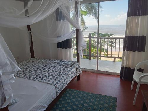 马特勒Himana Beach Rest的一间卧室配有一张床,享有海景